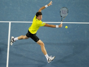 Milos Raonic hits a backhand return to Lleyton Hewitt during their third round match at the Australian Open tennis championship, in Melbourne, Australia, Saturday, Jan. 21, 2012. (AP Photo/Andrew Brownbill)