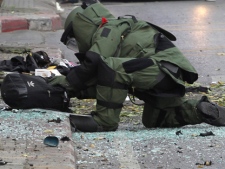 An Explosive Ordnance Disposal (EOD) official checks a backpack that was left by a suspected bomber in Bangkok, Thailand on Tuesday, Feb. 14, 2012. (AP Photo/Apichart Weerawong)