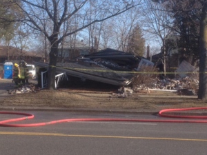 Firefighters stand next to a home on Cawthra Road in Mississauga after it collapsed Wednesday, Feb. 22, 2012. (CP24/Cam Woolley)