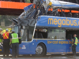 In this file photo from Sept. 11, 2010, investigators are pictured at the scene of a fatal double-decker Megabus accident just outside Syracuse, N.Y. (AP Photo/The Post-Standard, Peter Chen, File)