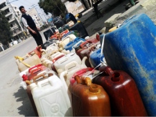 A Syrian man stands next to empty bottle as he waits to fill gasoline at a gas station in Damascus, Syria, Wednesday, March 7, 2012. The U.N. humanitarian chief headed to the shattered central Syrian city of Homs on Wednesday, where activists have accused regime forces of trying to cover up evidence of a monthlong military assault and alleged execution-style killings. (AP Photo)