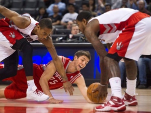 Toronto Raptors guard DeMar DeRozan, left, and Raptors forward Amir Johnson, right, battles for the loose ball against Houston Rockets forward Chandler Parsons, centre, during first half NBA basketball action in Toronto on Wednesday, March 7, 2012. (THE CANADIAN PRESS/Nathan Denette)