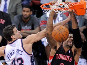 Toronto Raptors' James Johnson, right, dunks the ball over New Jersey Nets' Kris Humphries during the second quarter of an NBA basketball game on Wednesday, March 14, 2012, in Newark, N.J. (AP Photo/Bill Kostroun)