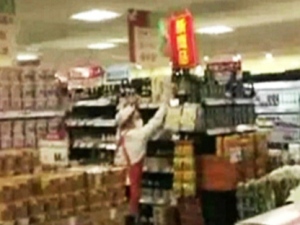 This screen grab taken from video shows a store employee trying to steady a shelf during one of two earthquakes that rattled Japan late Wednesday, March 14, 2012.