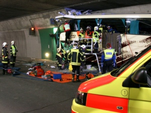 Rescuers and police work amid the wreckage of a tourist bus from Belgium at an accident site in a tunnel of the A9 highway near Sierre, Switzerland early Wednesday, March 14, 2012. A bus carrying Belgian students returning from a ski holiday crashed into a wall, killing 22 Belgian 12-year-olds and six adults, police said Wednesday. (AP Photo/KANTONSPOLIZEI WALLIS/POLICE OF VALAIS, Handout)