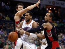 Charlotte Bobcats guard D.J. Augustin, center, is fouled as he drives between Toronto Raptors Andrea Bargnani, left, of Italy, and Jerryd Bayless in the first half of an NBA basketball game Saturday, March 17, 2012 in Charlotte, N.C. (AP Photo/Nell Redmond)