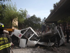 Firefighters work to remove a cement beam that fell from a bridge onto a public bus after an earthquake was felt in Mexico City on Tuesday, March 20, 2012. A strong 7.4-magnitude earthquake hit central and southern Mexico on Tuesday, collapsing at least 60 homes near the epicenter and a pedestrian bridge in the capital where people fled shaking office buildings in fear. There were no passengers in the mini-bus and the driver suffered minor injuries, according to firefighters. (AP Photo/Alexandre Meneghini)