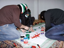 Anti-Syrian regime activists cover their faces with Syrian revolution flag cloths as they prepare a banner to be held in a protest, in Damascus, Syria, Wednesday, March 21, 2012. The previously divided U.N. Security Council sent a strong and united message to the Syrian government and opposition on Wednesday to immediately implement proposals by international envoy Kofi Annan to end the yearlong bloodshed. (AP Photo)