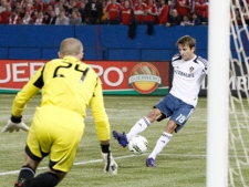 L.A. Galaxy's Mike Magee (right) sweeps the ball past Toronto FC goalkeeper Stefan Frei to score during first half action in the CONCACAF Champions League quarter final action in Toronto on Wednesday March 7, 2012. THE CANADIAN PRESS/Chris Young