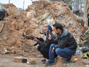 In this picture taken on Sunday March 25, 2012, Syrian rebels take their position behind a sand barrier, in the Khaldiyeh neighborhood in Homs province, central Syria. (AP Photo)