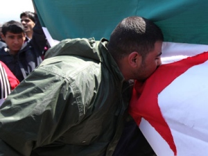 An anti-Syrian regime protester kisses a Syrian revolutionary flag during a demonstration after Friday prayer in Beirut, Lebanon, Friday, March 30, 2012. Fresh clashes between Syrian soldiers and rebels erupted Friday as the country's relentless violence overshadowed hopes for a peace plan brokered by U.N. envoy Kofi Annan. (AP Photo/Bilal Hussein)