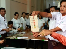 Myanmar officials show a ballot paper to people as they adjudicate on a vote for Aung San Suu Kyi's National League for Democracy party, as the mark is placed against the name, during the vote count at a polling station in Dagon port township in Yangon, Myanmar, Sunday, April 1, 2012. Supporters of Suu Kyi erupted in euphoric cheers Sunday after her party announced she had won a parliamentary seat in a landmark election, setting the stage for her to take public office for the first time. (AP Photo/Khin Maung Win)