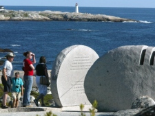 People walk past a memorial for victims of Swiss Air flight 111 near Peggy's Cove, N.S., on Thursday, Sept. 2, 2004. On Sept. 2, 1998, 229 people died when the flight crashed off the coast of Nova Scotia. (CP PHOTO/Jonathan Hayward)