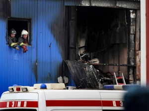 Firefighters and Emergency Ministry officers examine the scene of a fire at Kachalovo construction market on Tuesday, April 3, 2012. A blaze at a market on the outskirts of Moscow killed migrant workers sleeping in a metal shed on the premises, the city fire department said. All were citizens of former Soviet nations in Central Asia. (AP Photo/ Maxim Dmitriyev)