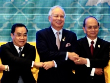 Leaders from the Association of Southeast Asian Nations (ASEAN), from left, Prime Minister Thongsing Thammavong of Laos, Malaysia's Prime Minister Najib Razak and Myanmar's President Thein Sein join hands during a group photo at the opening ceremony of the 20th ASEAN Summit in Phnom Penh, Cambodia Tuesday, April 3, 2012. (AP Photo/Apichart Weerawong)