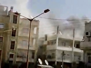 This image made from amateur video and released by Shaam News Network on Monday, April 2, 2012, purports to show smoke rising from a building in Idlib, Syria. (AP Photo/Shaam News Network via APTN)