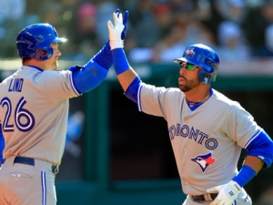 Toronto Blue Jays' Jose Bautista is greeted by Adam Lind (26) after Bautista's solo home run off Cleveland Indians starting pitcher Justin Masterson in the fourth inning of an opening day baseball game on Thursday, April 5, 2012, in Cleveland. (AP Photo/Mark Duncan)