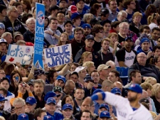 Toronto Blue Jays fans hold up signs as Jose Bautista warms up ahead of their home opener against the Boston Red Sox in Toronto on Monday April 9, 2012. (THE CANADIAN PRESS/Chris Young)