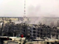 In this image made from amateur video released by the Shaam News Network and accessed Sunday, April 15, 2012, smoke rises from buildings across the city following purported shelling in Homs, Syria. Syrian troops are reported to have shelled residential neighborhoods dominated by rebels in the central city of Homs Sunday, activists said, killing at least three people hours before the first batch of United Nations observers were to arrive in Damascus to shore up a shaky truce. (AP Photo/Shaam News Network via AP video)