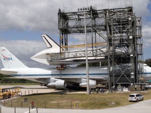 In this file photo provided by NASA, workers attach space shuttle Discovery to the Shuttle Carrier Aircraft in the mate-demate device at the Kennedy Space Center in Cape Canaveral, Fla., Sunday, April 15, 2012. Discovery will be transported to the Smithsonian National Air and Space Museum in Washington on Tuesday, April 17. (AP Photo/NASA, Kim Shiflett)