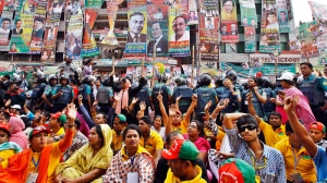 Police officials stand guard as Bangladesh's main opposition Bangladesh Nationalist Party supporters shout slogans during a rally outside their party headquarters in Dhaka, Bangladesh