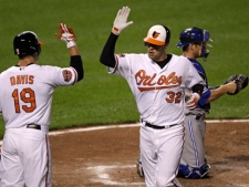 Baltimore Orioles' Matt Wieters (32) high-fives Chris Davis after crossing home plate for a solo home run in the fourth inning of a baseball game against the Toronto Blue Jays in Baltimore on Tuesday, April 24, 2012. (AP Photo/Patrick Semansky)