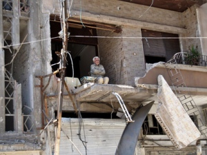 In this Sunday April 22, 2012 photo, a Syrian man sits on the balcony of his destroyed house damaged from Syrian army forces shelling, at Hamidiyeh neighborhood in Homs province, central Syria. (AP Photo)