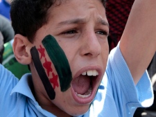 An anti-Syrian regime protester, his face painted with a replica of the Syrian revolution, shouts slogans against Syrian President Bashar Assad during a demonstration after Friday prayers in Beirut, Lebanon, Friday April 27, 2012. (AP Photo/Hussein Malla)