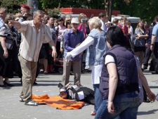 People assist an injured person after an explosion in Dnipropetrovsk, Ukraine, Friday, April 27, 2012. Officials say four blasts within minutes rocked the centre of the eastern Ukrainian city in what prosecutors believed was a terrorist attack. (AP Photo/Dmitriy Dvorsky)