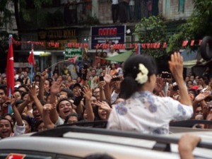 Myanmar pro-democracy icon Aung San Suu Kyi waves to supporters from her vehicle as she arrives to attend an inauguration ceremony of a branch office of her National League for Democracy (NLD) party in Yangon, Myanmar on Tuesday, May 1, 2012. (AP Photo/Khin Maung Win)