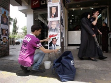 A Syrian worker places a poster of a paramilitary candidate for the upcoming elections, in Damascus, Syria, on Wednesday, May 2, 2012. Preparations are underway in Syria for the parliamentary elections slated for May 7, 2012, as the crisis in the country drags on. (AP Photo/Muzaffar Salman)