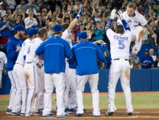 Toronto Blue Jays third baseman Brett Lawrie, right, jumps into home plate after scoring the game winning walkoff home run to beat the Texas Rangers during ninth inning AL action in Toronto on Tuesday, May 1, 2012. (THE CANADIAN PRESS/Nathan Denette)