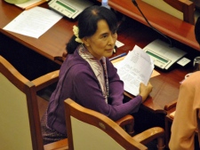 Myanmar pro-democracy icon Aung San Suu Kyi talks with a Myanmar lawmaker as she attends a regular session of Myanmar Lower House at parliament in Naypyitaw, Myanmar, Wednesday, May 2, 2012. Suu Kyi was sworn in to Myanmar's military-backed parliament, taking public office for the first time since launching her struggle against authoritarian rule nearly a quarter century ago. (AP Photo/Khin Maung Win)