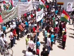 This image made from amateur video released by the Shaam News Network and accessed Friday, May 4, 2012, purports to show Syrians chanting slogans and caring Kurdish flags during a demonstration in Qamishli, the capital of Syria's Kurdish heartland. (AP Photo/Shaam News Network via AP video)