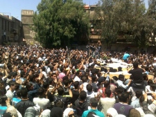 In this picture taken with a mobile phone, anti-Syrian regime mourners shout slogans against their president Bashar Assad as they carry the bodies of five protesters, right, who were killed by Syrian security forces on Friday while taking part in the funeral of activist Odai Junblat, during their funeral procession, in the Kfar Suseh area in Damascus, Syria, on Saturday, May 5, 2012. (AP Photo)