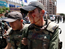 An injured Syrian army soldier, right, who was wounded after a roadside bomb hit his military truck, is helped by a comrade in Daraa, Syria on Wednesday, May 9, 2012. The explosion targeted the Syrian military truck just seconds after a team of U.N. observers passed by. (AP Photo/Muzaffar Salman)