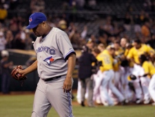 Toronto Blue Jays pitcher Francisco Cordero walks off the field as the Oakland Athletics celebrate after Brandon Inge hit a walkoff grand slam during the ninth inning of a game in Oakland, Calif., Tuesday, May 8, 2012. The Athletics won 7-3. (AP Photo/Jeff Chiu)