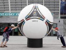 Kids try to push a model of an official ball of the Euro 2012 soccer tournament at the Olympiysky stadium in Kiev, Ukraine, Thursday, May 3, 2012. (AP Photo/Efrem Lukatsky)