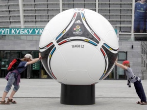 Kids try to push a model of an official ball of the Euro 2012 soccer tournament at the Olympiysky stadium in Kiev, Ukraine, Thursday, May 3, 2012. (AP Photo/Efrem Lukatsky)