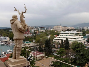 In this photo taken Thursday, May 19, 2011, an old Soviet style statue of a reindeer breeder, left, is seen over the Black Sea resort of Sochi, Russia. (AP Photo/Alexander Zemlianichenko, file)