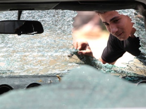 A Lebanese man looks through a damaged car window that was hit by bullets during sectarian clashes between Sunni and Alawite gangs on Syria Street which divides the Sunni and Alawite areas, in the northern port city of Tripoli, Lebanon, on Tuesday, May 15, 2012. Lebanese troops deployed Tuesday in tense areas of the northern city of Tripoli after three days of sectarian clashes killed at least six people in a spillover of the 14-month-long conflict in neighboring Syria. (AP Photo/Hussein Malla)