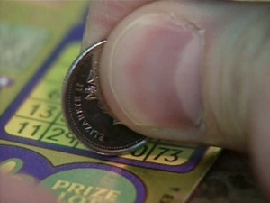 A lottery player tries their luck with a scratch and win ticket in Toronto.