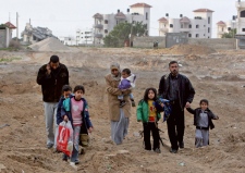 A Palestinian family leave their houses in Gaza City after the Israeli army stepped back to positions outside their neighbourhood, Friday, Jan. 16, 2009. (AP / Khalil Hamra)