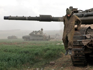 An Israeli soldier jumps down from a tank at a staging area on the Israel-Gaza border, on Saturday, Jan. 17, 2009. (AP / Tsafrir Abayov)