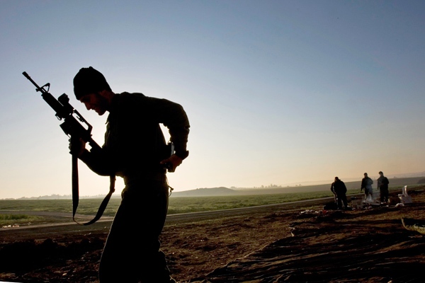 An Israeli soldier holds his machine gun as he walks near Israel's border with the Gaza Strip, in southern Israel, Wednesday, Jan. 21, 2009. (AP / Bernat Armangue)