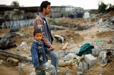 A Palestinian boy holds the hand of his father as they arrive to inspect their destroyed house in the southern part of Gaza City, Tuesday, Jan. 20, 2009. (AP / Anja Niedringhaus)