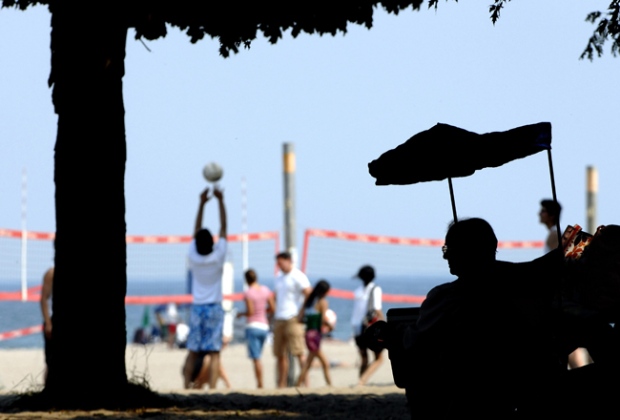Jose DaSilva keeps cool in the shade as volleyball players practice on Woodbine Beach in Toronto, Thursday, Aug. 2, 2007. Woodbine is one of six Blue Flag beaches in Toronto. (Aaron Harris / THE CANADIAN PRESS)