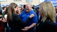 Ontario PC leader Doug Ford embraces York-Simcoe candidate Caroline Mulroney as Newmarket-Aurora candidate Christine Elliott looks on, at a breakfast meet and greet in Ottawa on Saturday, June 2, 2018. THE CANADIAN PRESS/Justin Tang