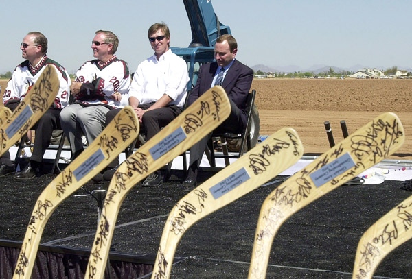 From left, Phoenix Coyotes owners Steve Ellman, Jerry Moyes and Wayne Gretzky and NHL commissioner Gary Bettman sit near the site of the Coyotes' future arena in Glendale, Ariz. on Wednesday, April 3, 2002. (AP / Matt York)