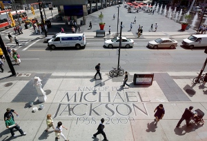 Pedestrians walk past a tribute  to the late Michael Jackson written on the sidewalk on Dundas Square in Toronto on Friday June 26, 2009. (THE CANADIAN PRESS/Darren Calabrese)